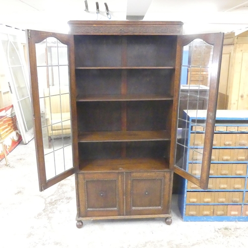 2545 - An early 20th century oak bookcase, with two lattice glazed doors and cupboards under. 94x189x32cm.