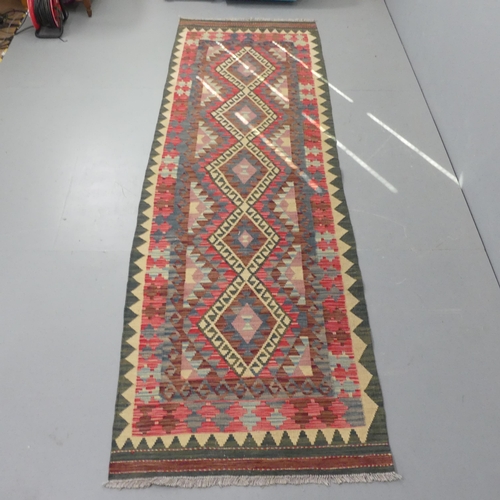 2276 - A red and green-ground Kilim runner. 300x90cm.