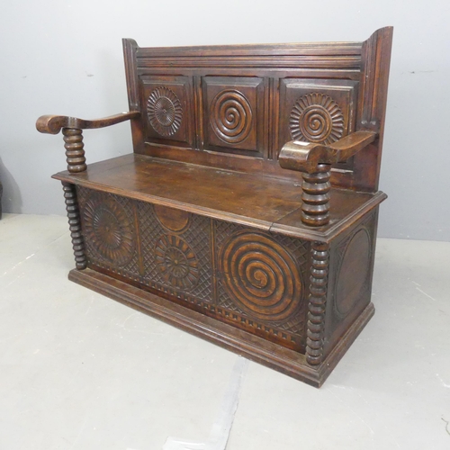 2519 - An early 20th century Breton French panelled oak hall bench, with lifting seat and carved decoration... 