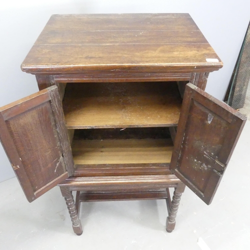 2529 - An early 20th century oak Jacobean style cabinet on stand, with two fielded panelled doors, bobbin t... 