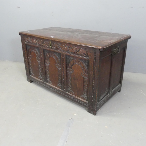 2531 - An 18th century paneled oak coffer, with carved decoration and raised on stile legs. 107x60x54cm.