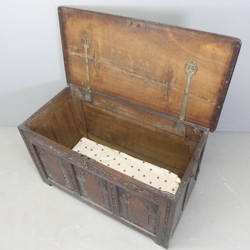 2531 - An 18th century paneled oak coffer, with carved decoration and raised on stile legs. 107x60x54cm.