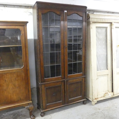 2545 - An early 20th century oak bookcase, with two lattice glazed doors and cupboards under. 94x189x32cm.