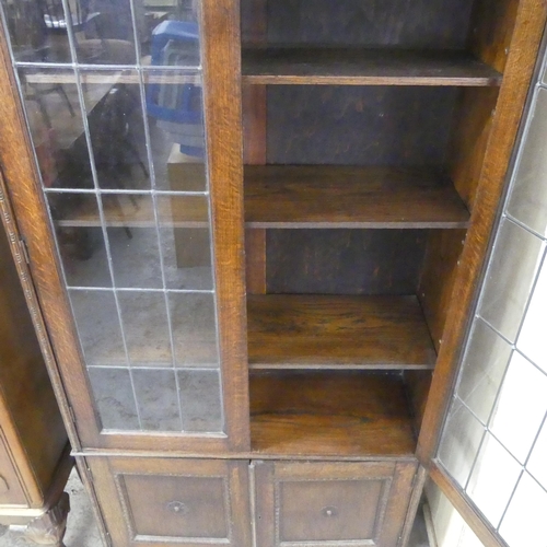 2545 - An early 20th century oak bookcase, with two lattice glazed doors and cupboards under. 94x189x32cm.