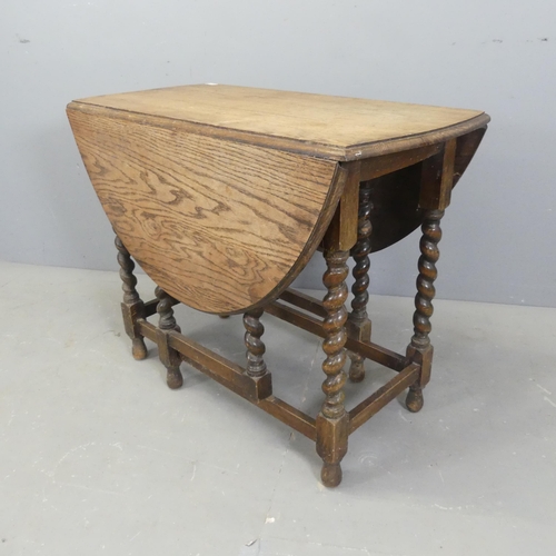 2559 - An early 20th century oak oval gate-leg table with barley twist legs. 92x74x48cm.