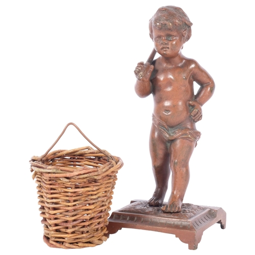 134 - A small cast-bronze match striker, in the form of a small boy carrying a wicker basket, H14.5cm