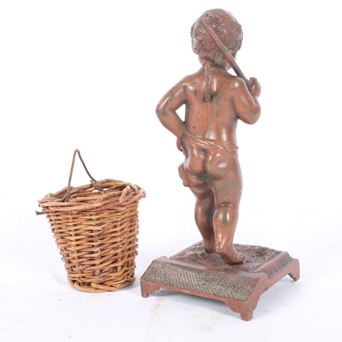 134 - A small cast-bronze match striker, in the form of a small boy carrying a wicker basket, H14.5cm