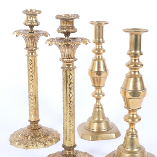 18 - A pair of ornate embossed brass candlesticks (missing lustre drops), H33cm, and a pair of brass wais... 