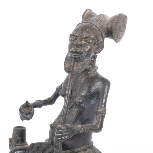 22 - A cast-bronze figure, Yoruba, Nigeria?, study of a seated man smoking a pipe, H29cm