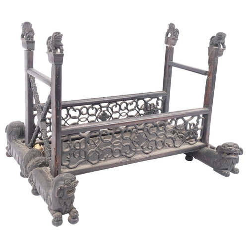 225 - An Oriental carved and pierced hardwood stand, raised on dog of fo supports, W55cm