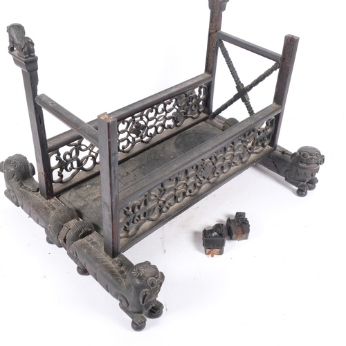 225 - An Oriental carved and pierced hardwood stand, raised on dog of fo supports, W55cm