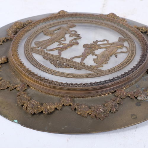 247 - An Antique circular brass and glass plaque, with applied swag and rose decoration and Grecian figure... 