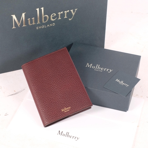 321 - MULBERRY - a leather passport cover, crafted from grained oxblood leather, opening to a smoother lea... 