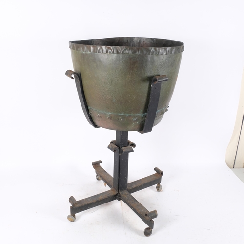 324 - An Antique riveted copper cauldron, on modern wrought-iron stand, with wheels, overall height includ... 