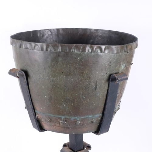 324 - An Antique riveted copper cauldron, on modern wrought-iron stand, with wheels, overall height includ... 