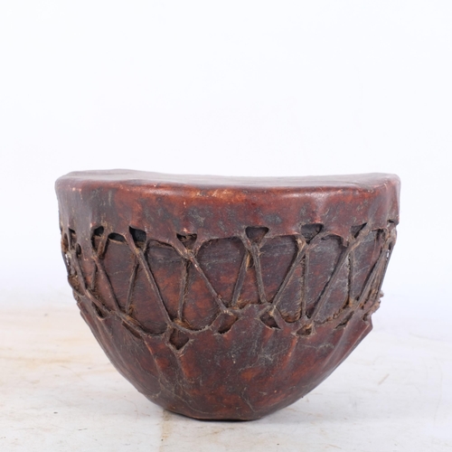 410 - A hide-covered African gourd drum, 19.5cm across