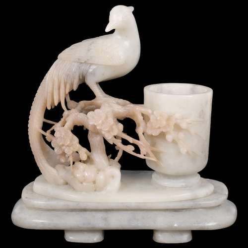 437 - A carved stone vase on plinth, with pheasant and blossom design, 19cm