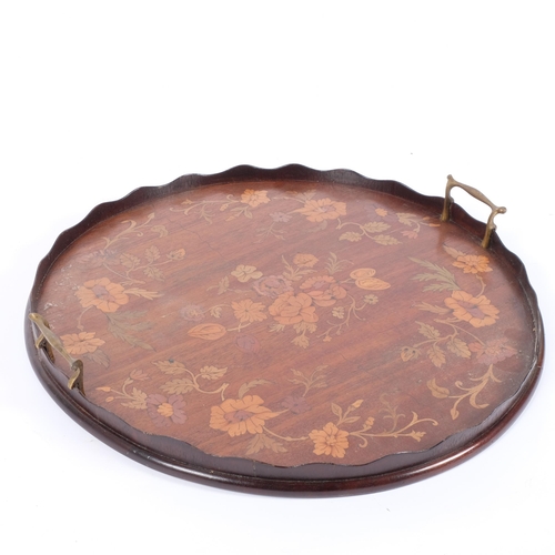 46 - An Edwardian mahogany circular galleried tea tray with brass handles, and floral painted decoration,... 