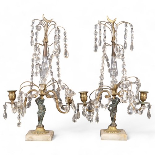 71 - A pair of gilt-metal table candelabras with gilt lustre drops, resting upon a putti, raised on a squ... 