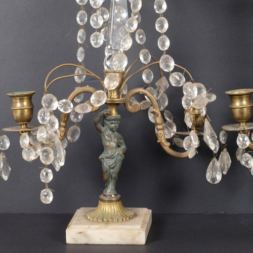 71 - A pair of gilt-metal table candelabras with gilt lustre drops, resting upon a putti, raised on a squ... 