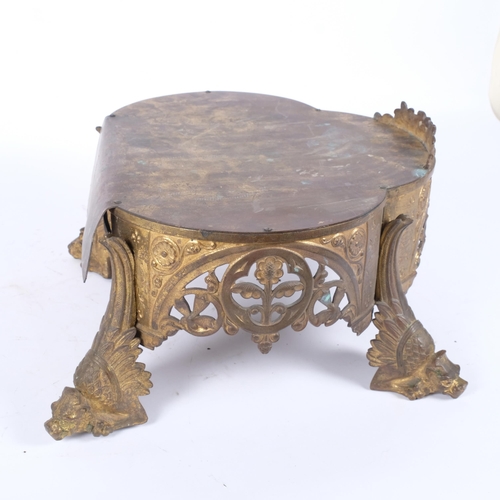 79 - A 19th century gilt-brass stand of shaped form, with embossed and pierced decoration, raised on 4 my... 