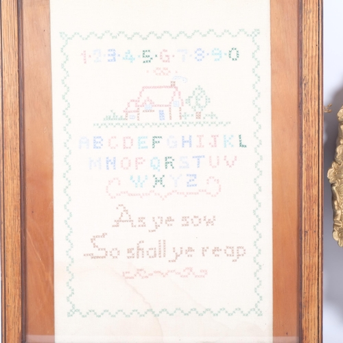 90 - A needlework sampler, framed, and a gilt plaster framed wall mirror (2)