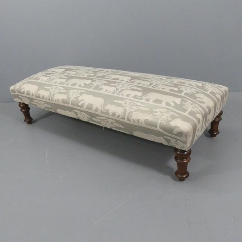 2341 - A large upholstered footstool with animal design raised on turned mahogany legs. 160x40x65cm