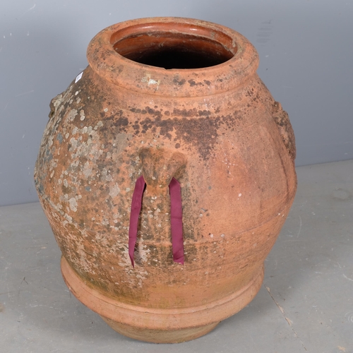 2801 - A large weathered terracotta olive oil jar, with two handles and armorial lion crest decoration. 70x... 