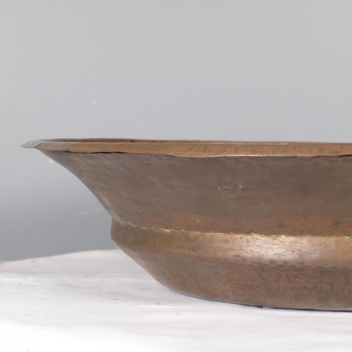 2830 - An Arts & Crafts style spun and beaten copper bowl. 52x13cm.