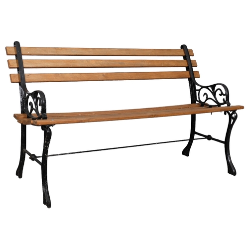 2880 - A pine slatted garden bench with painted cast-iron ends. Overall 121x70x55cm.