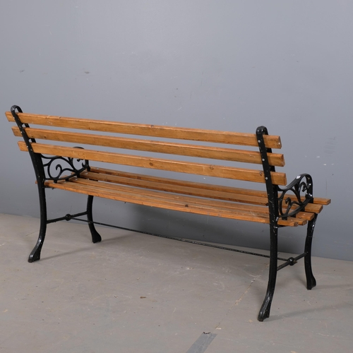 2880 - A pine slatted garden bench with painted cast-iron ends. Overall 121x70x55cm.