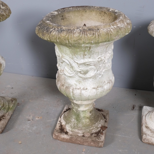 2904 - A set of three painted and weathered concrete garden urns on stands, with egg and tongue decoration.... 