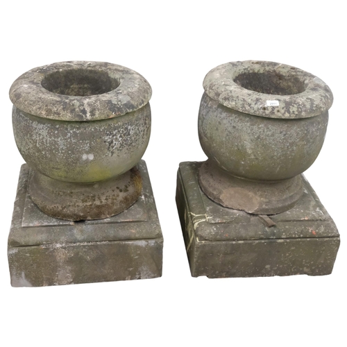 2911 - A pair of weathered-stone two-section urns on plinth bases. Overall 53x70cm.