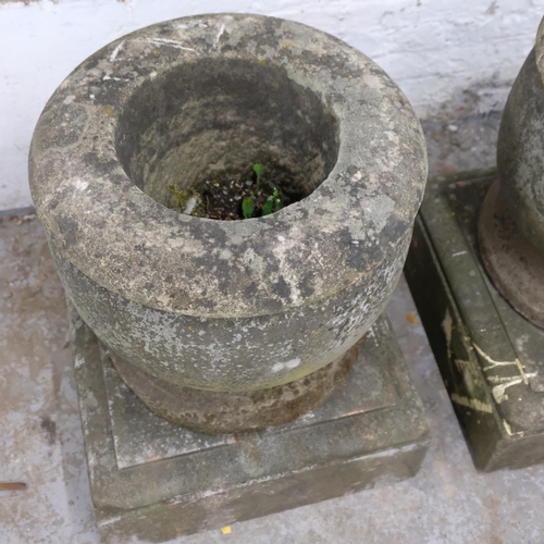 2911 - A pair of weathered-stone two-section urns on plinth bases. Overall 53x70cm.