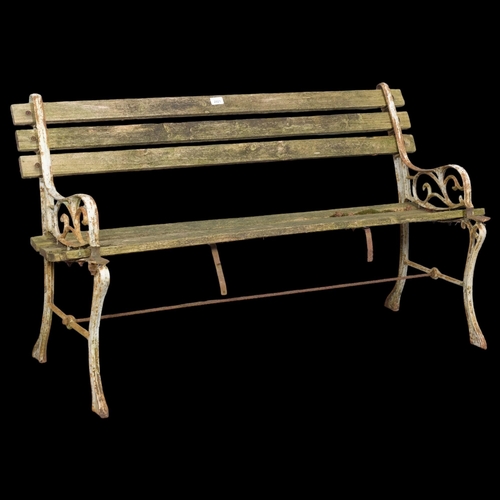 2921 - A teak slatted garden bench with painted cast iron ends. Overall 121x70x50cm.