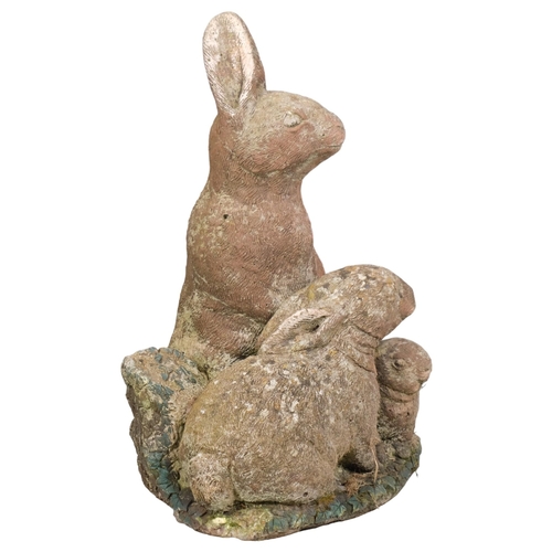 2930 - A painted concrete garden sculpture, depicting a family of rabbits. Height 47cm.