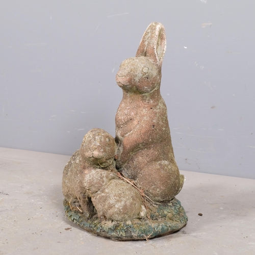 2930 - A painted concrete garden sculpture, depicting a family of rabbits. Height 47cm.