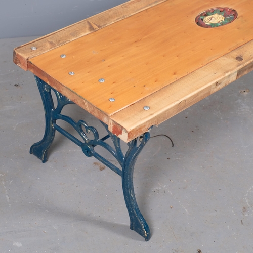 2942 - A pine garden bench / low table with cast iron base, with inset painted floral panel. 109x40x42cm.