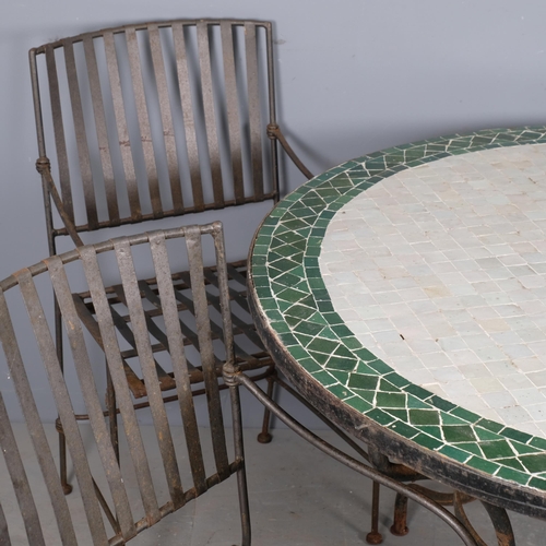 2946 - A circular tile-topped garden table on cast iron base, 120x76cm, and a set of four wrought-iron fold... 