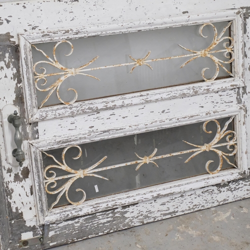 2976 - A painted pine door, with glazed and wrought iron panels. 101x210cm.