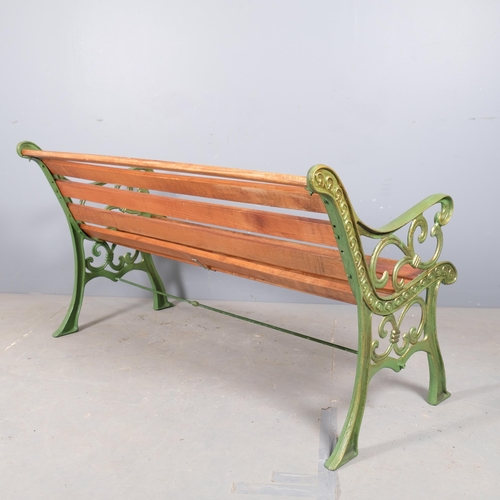 2985 - A mahogany-slatted garden bench with painted cast-iron ends. 145x77x70cm.