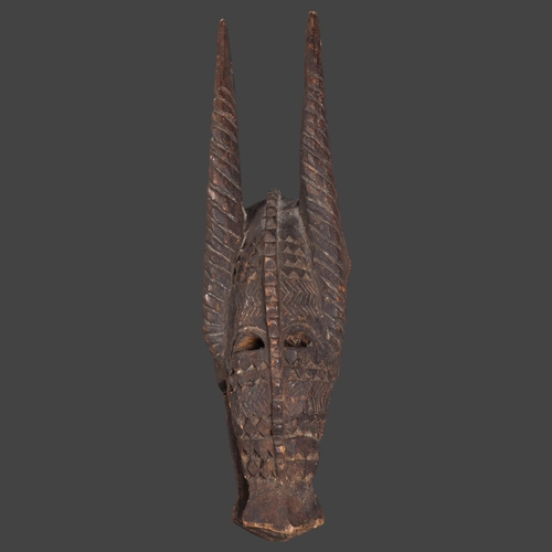 3098 - An African tribal carved wood Senufo Bobo zoomorphic helmet mask in the form of a horned creature, h... 