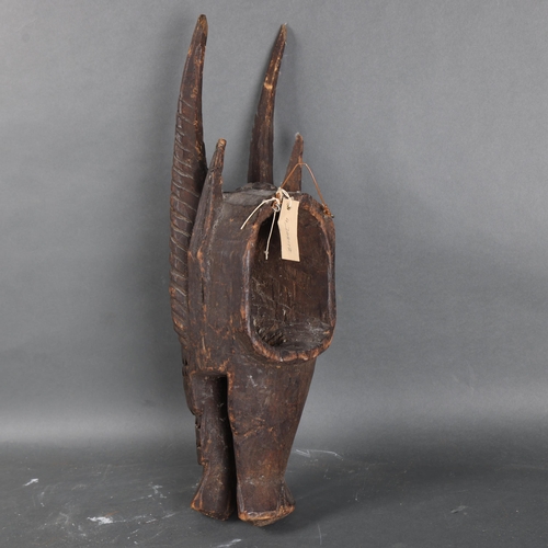 3098 - An African tribal carved wood Senufo Bobo zoomorphic helmet mask in the form of a horned creature, h... 