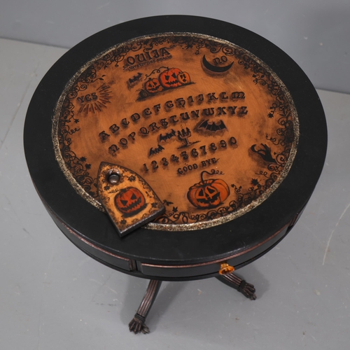 3115 - Curiosity/Macabre : A Ouija board pumpkin design drum table, with planchette, 50cm x 60cm, planchett... 