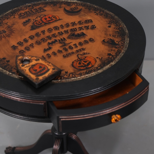 3115 - Curiosity/Macabre : A Ouija board pumpkin design drum table, with planchette, 50cm x 60cm, planchett... 