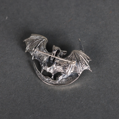 3240 - Curiosity/Macabre: Silver Pendant / Brooch in the form of a bat with facet cut pink sapphire or ruby... 