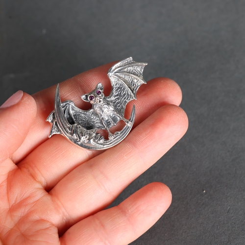 3240 - Curiosity/Macabre: Silver Pendant / Brooch in the form of a bat with facet cut pink sapphire or ruby... 