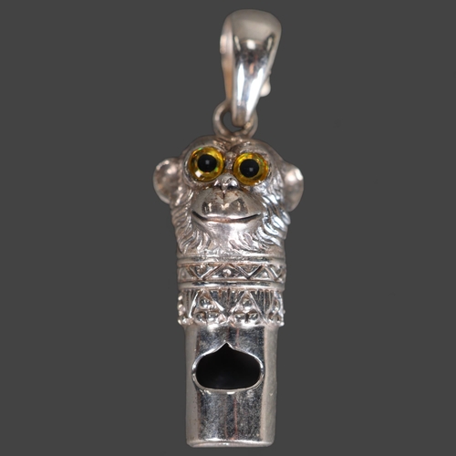 3249 - Natural History: A silver Pendant / whistle in the form of a monkey head with yellow glass eyes