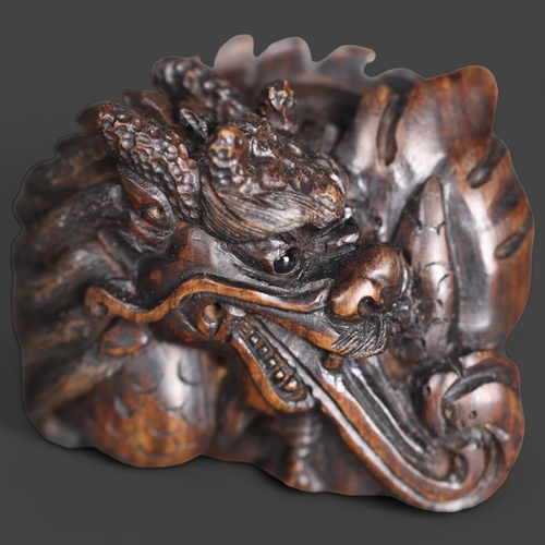 3274 - Netsuke: Japanese Dragon. Hand carved hardwood netsuke, with inlaid bone disc signature, of a Japane... 