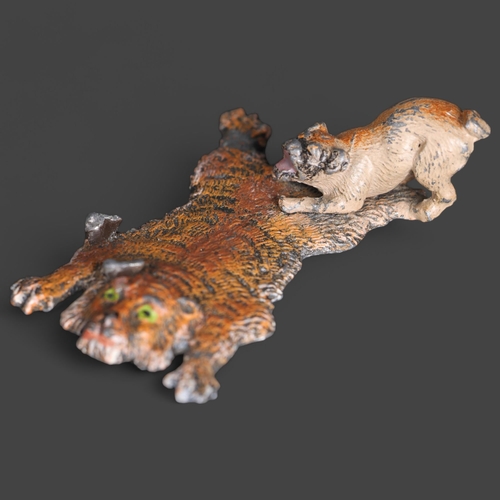 3282 - An Antique painted spelter study of a tiger skin rug and Pug dog, unsigned, length 7cm.